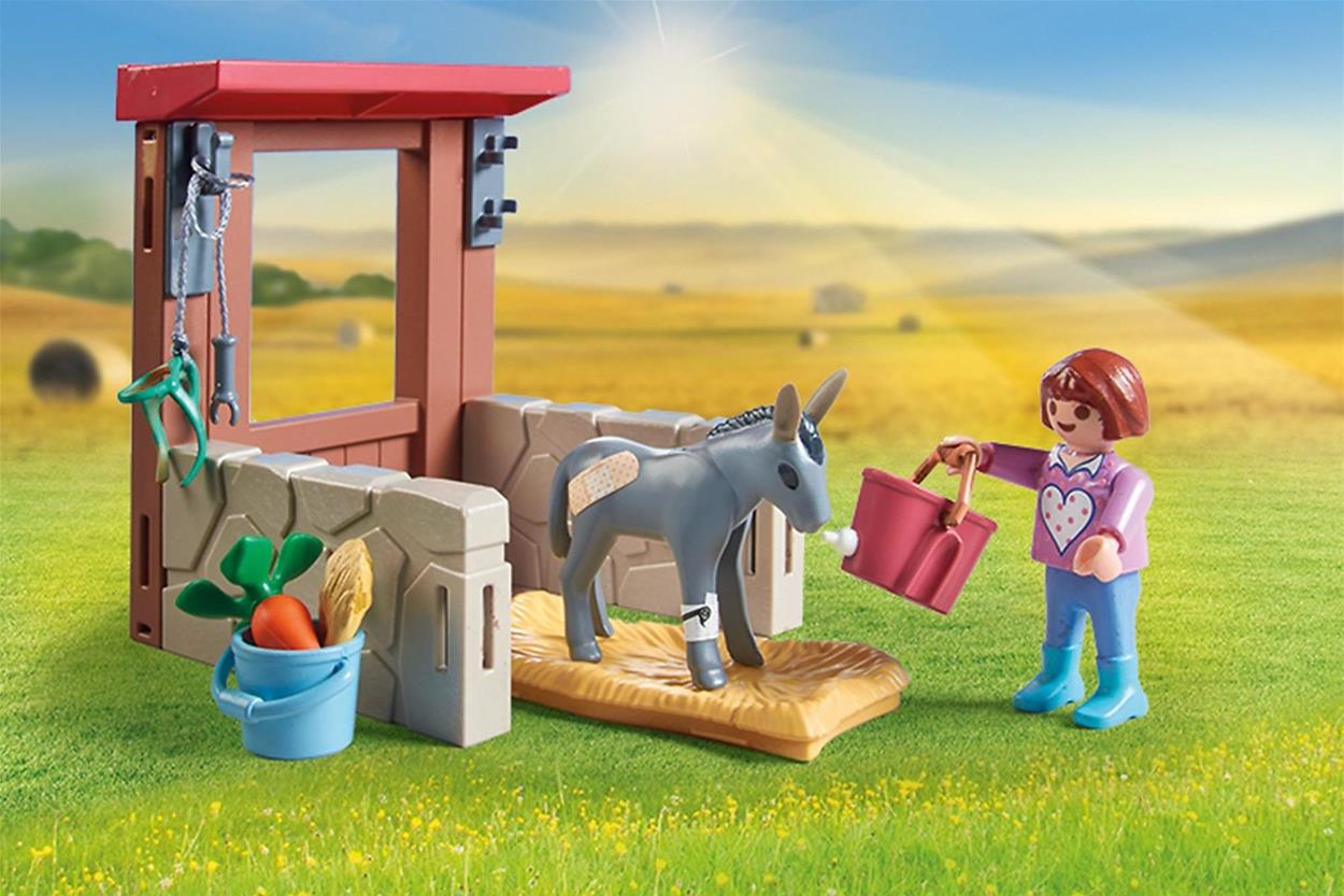 Das Mädchen aus dem Playmobil-Bausatz Veterinärausflug zu Eseln kümmert sich um einen Esel