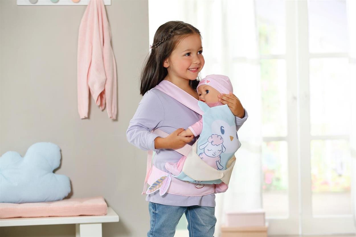 Dívka nesoucí panenku Baby Annabell v nosítku