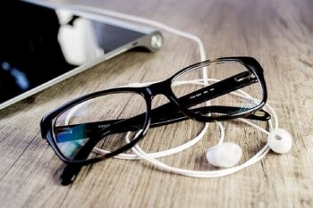 Černé plastové dioptrické brýle na čtení i na dálku ležící u počítače