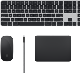 Pohled shora na doplňky k Macu: Magic Keyboard, Magic Mouse, Magic Trackpad a Thunderbolt kabely.