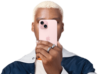 Osoba si pred tvárou drží iPhone 15, aby skryla svoju identitu