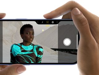 Uživatel drží iPhone 16 a fotí snímek