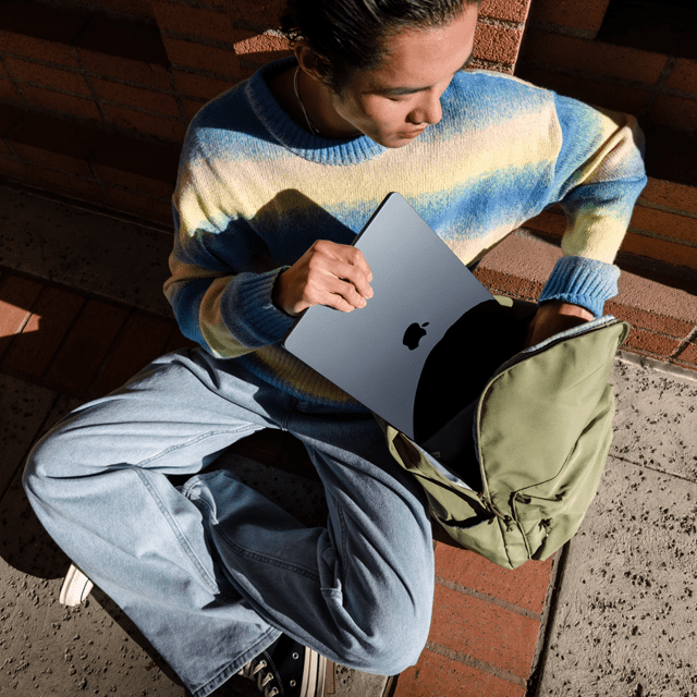 Pohľad spredu na osobu, ktorá si dáva 15-palcový MacBook Air do tašky – Apple notebook – MacBook MacBook Air 13-palcový M3 SK 2024 Temne atramentový