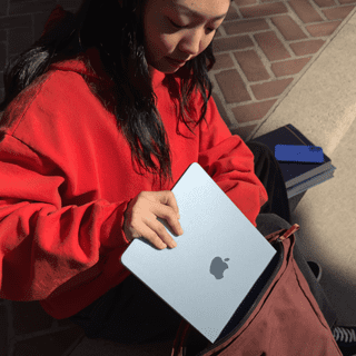 Studentka si dává 15palcový MacBook Air do batohu