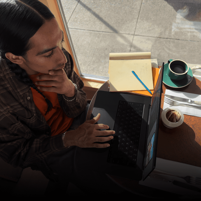 Človek pracujúci na odpojenom MacBooku Pro v kaviarni